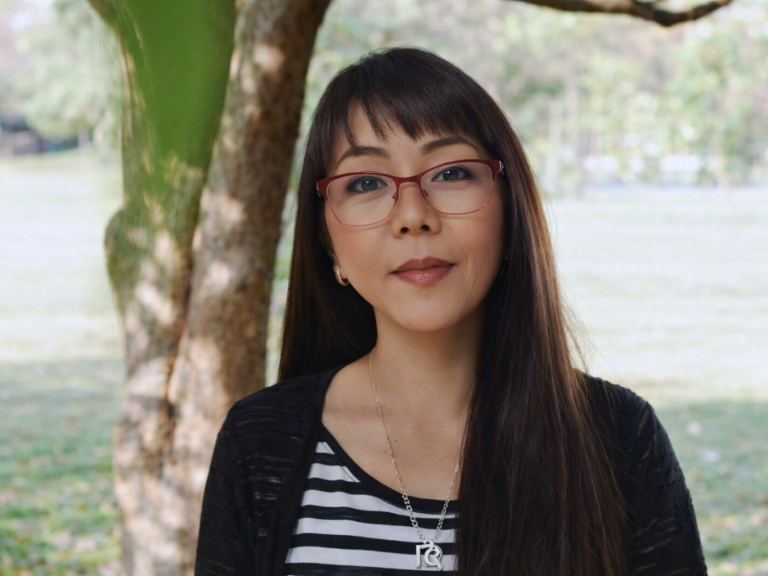 Porträt von Wasana mit scharzen Haaren, die in die Kamera lächelt.