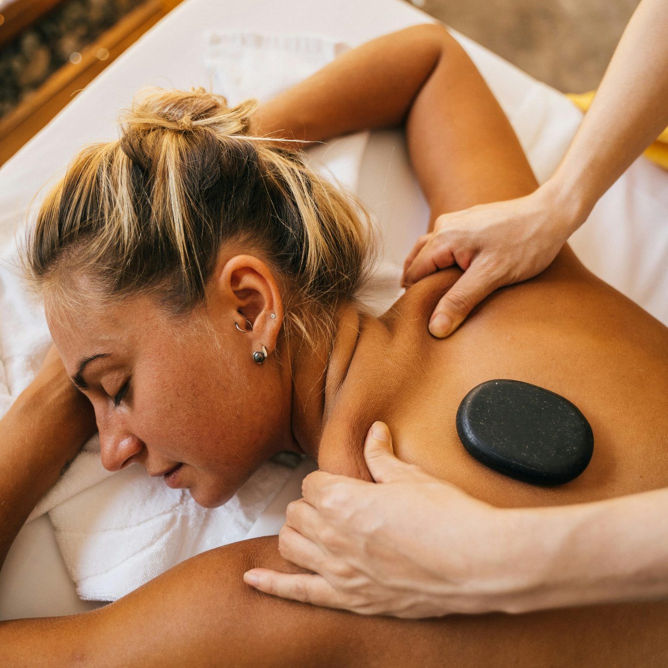Hot-Stone Massage Frau erhält eine Rückenmassage mit einem heißen Stein. Entspannung und Wellness.
